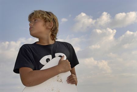 Boy posing in the beach with a skim-boardの写真素材