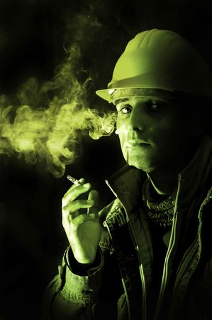 Construction worker smoking isolated in blackの写真素材