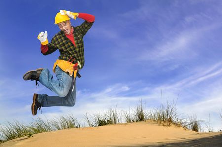 Happy construction worker jumping outdoorsの写真素材