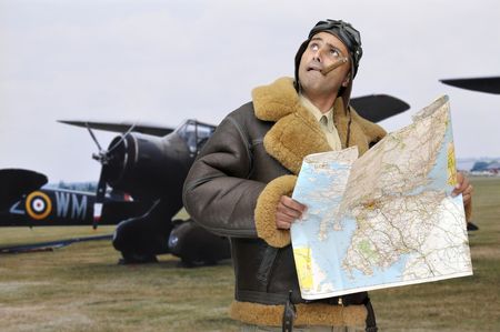 WWII fighter pilot with map looking to the skyの写真素材