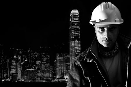 Constructor worker posing in a dark city backgroundの写真素材