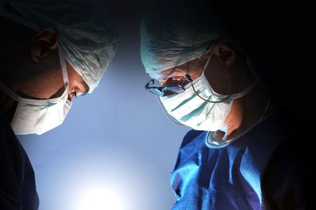 Doctors team in surgery in a dark backgroundの写真素材