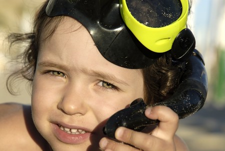 Young boy posing in the beach with scuba gogglesの写真素材