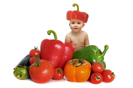 Beautiful baby in a group of vegetables isolated in whiteの写真素材