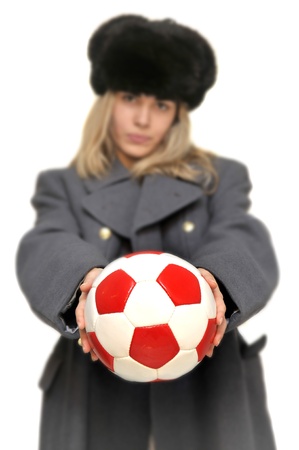 Out of focus  girl in russian army greatcoat and lingerie holding a soccer ball isolated in whiteの写真素材