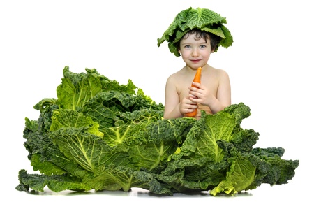 Beautiful young boy inside a cabbage eating a carrotの写真素材