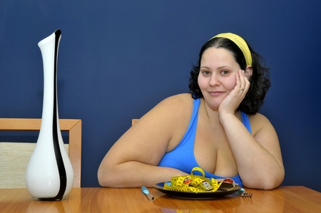 Large girl eating a measuring tapeの写真素材