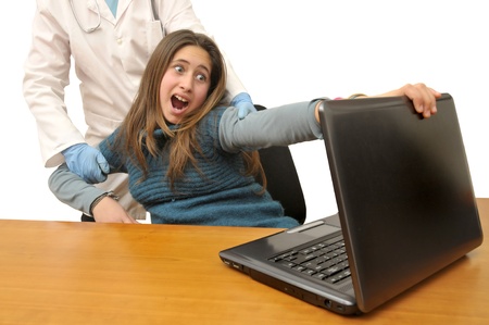 Stressed young girl in front of a laptop computer の写真素材
