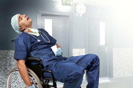Tired doctor sleeping in a wheelchair
