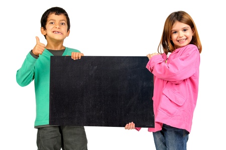 Children couple posing with a black board isolated in whiteの写真素材