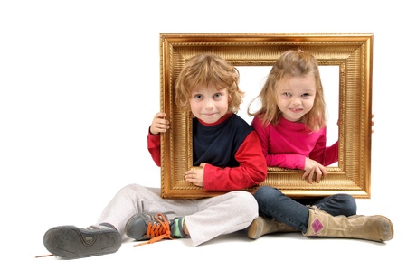 Children's couple posing with a golden frameの写真素材