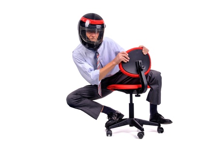 Businessman racing in a chair with helmetの写真素材