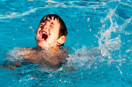 Young boy playing in the poolの写真素材