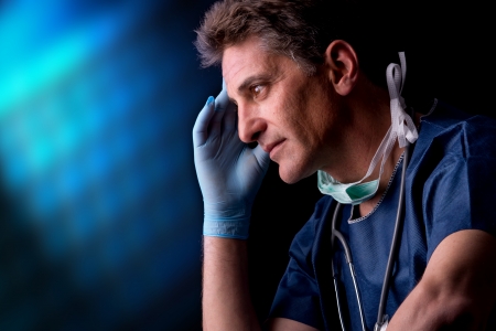 Tired doctor in uniform isolated against a black backgroundの写真素材