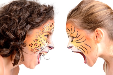 Beautiful young girls with feline painted faces, tiger and leopardの写真素材