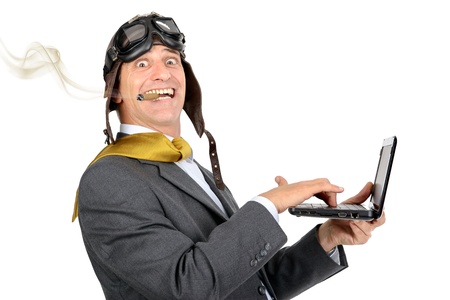Businessman with pilot goggles and laptop in full speedの写真素材