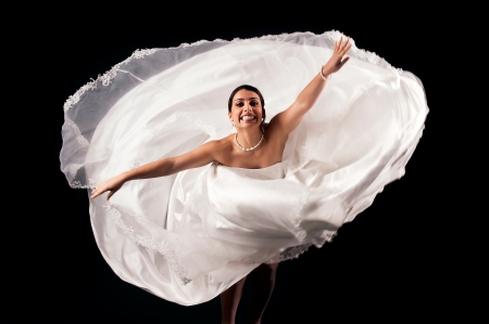 Beautiful bride dancing isolated in a dark backgroundの写真素材