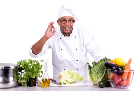 Male chef with fruits and vegetables on table, isolated on white backgroundの写真素材