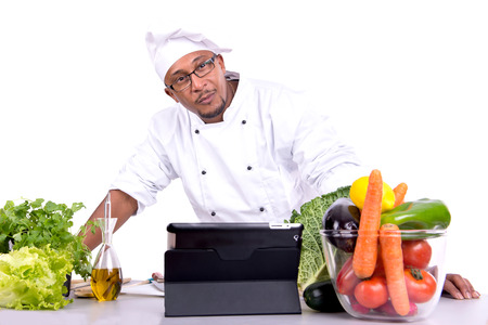 Male chef with fruits and vegetables and tablet for recipeの写真素材