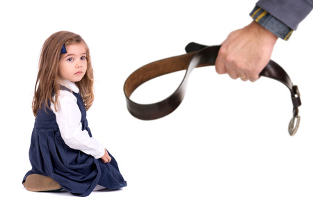 Young girl terrified od her father's physical punishment with a beltの写真素材