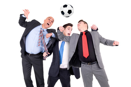 Businessmen playing soccer ball isolated in whiteの写真素材
