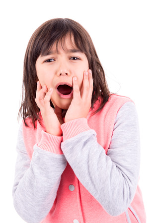 Funny young girl making faces isolated in whiteの写真素材
