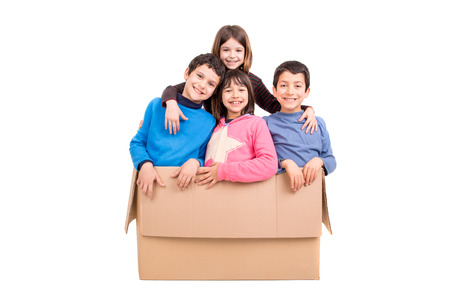 Happy kids inside a cardboard box isolated in whiteの写真素材