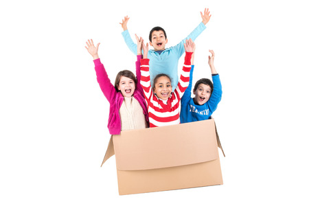Happy kids inside a cardboard box isolated in whiteの写真素材