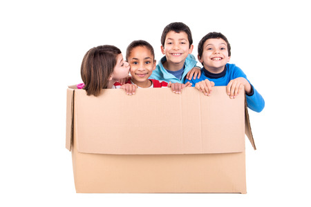 Happy kids inside a cardboard box isolated in whiteの写真素材