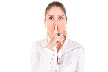 Beautiful young woman making silence gesture isolated in white