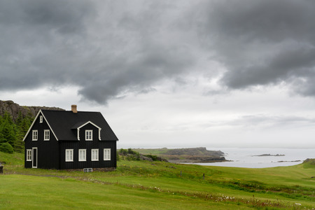 View of north Atlantic from an icelandic shore with beautiful black houseのeditorial素材