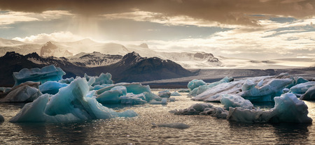 Reflections in Jokulsarlon lagoon in Iceland, by sunset