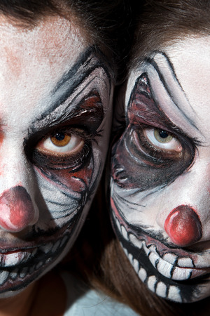 Teenage girls with scary clown face paintingの写真素材