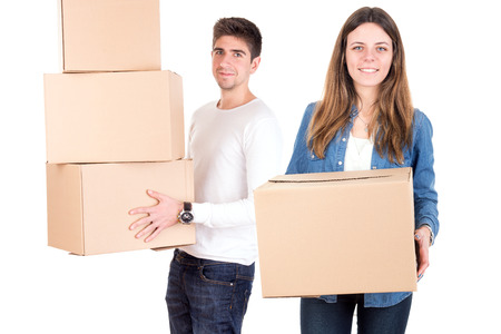 Happy couple with boxes moving into new home apartment 