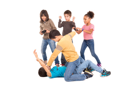 Boys fighting with other kids cheering and filmingの写真素材