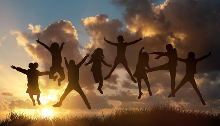 Group of children jumping outdoors against the sun