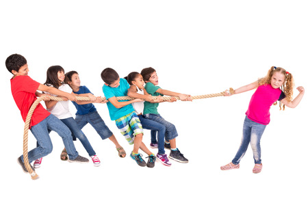 Group of children in a rope-pulling contest against just one strong girlの写真素材