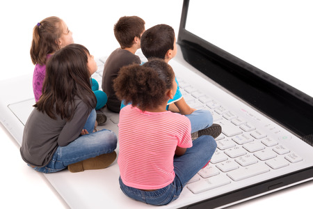 Group of young children in a laptop computer keyboard looking at the screenの写真素材