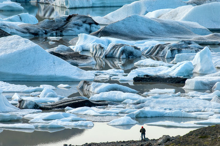 Photographer with tripod in a glacier lagoon in Icelandの写真素材