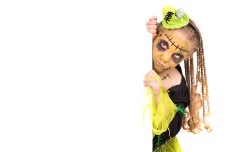 Girl with face-paint and Halloween monster costume over a white boardの写真素材