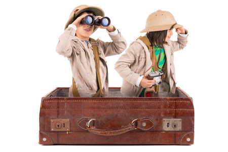 Children's couple in safari clothes playing inside a suitcaseの写真素材