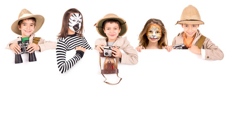 Children's group in safari clothes and face-paint over a white boardの写真素材