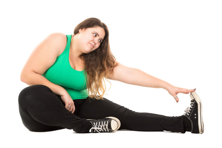 Beautiful large girl doing fitness exercises isolated in whiteの写真素材