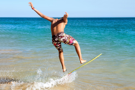Teenager surfing in the beachの写真素材
