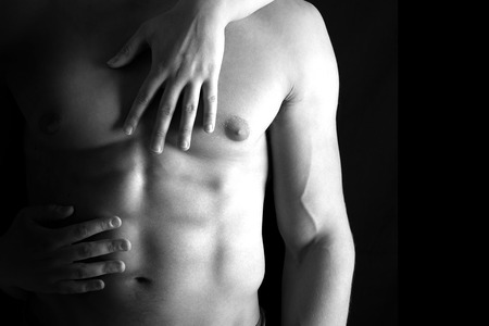 Ma's torso with woman's hands around isolated in blackの写真素材
