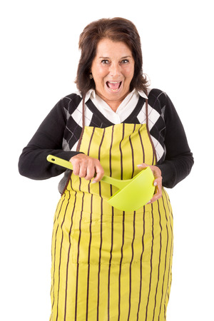 Beautiful senior woman with apron and spoon isolated in whiteの写真素材