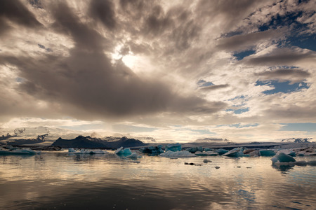 Reflections in Jokulsarlon lagoon in Iceland, by sunsetの写真素材