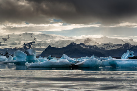 Reflections in Jokulsarlon lagoon in Iceland, by sunset