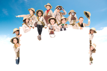 Children's group with safari clothes and gear over a white boardの写真素材
