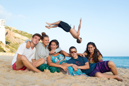 Group of happy teenage friends having fun at the beachの写真素材